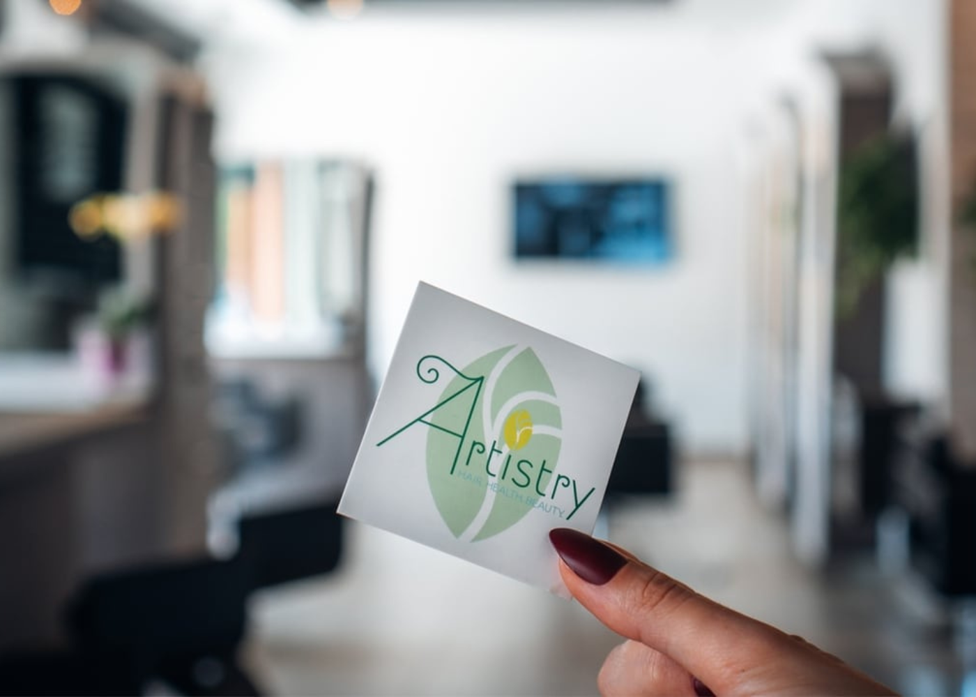 Fingers holding up an Artistry brand card