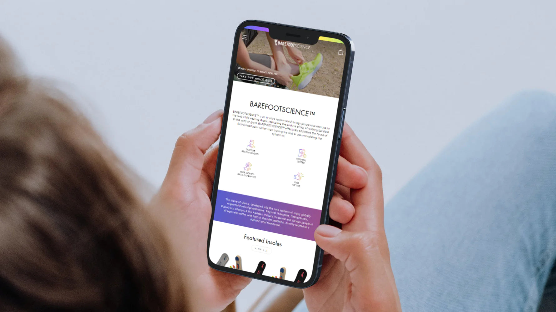 Person holding phone displaying Barefoot website