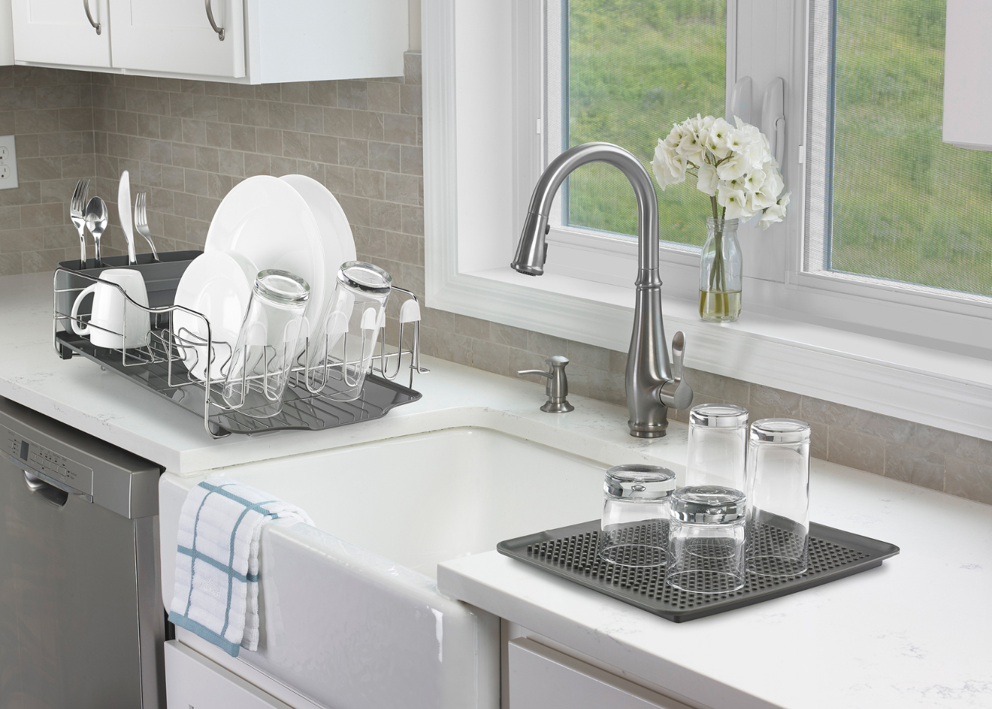 Kitchen counter with sink and drying rack holding dishes
