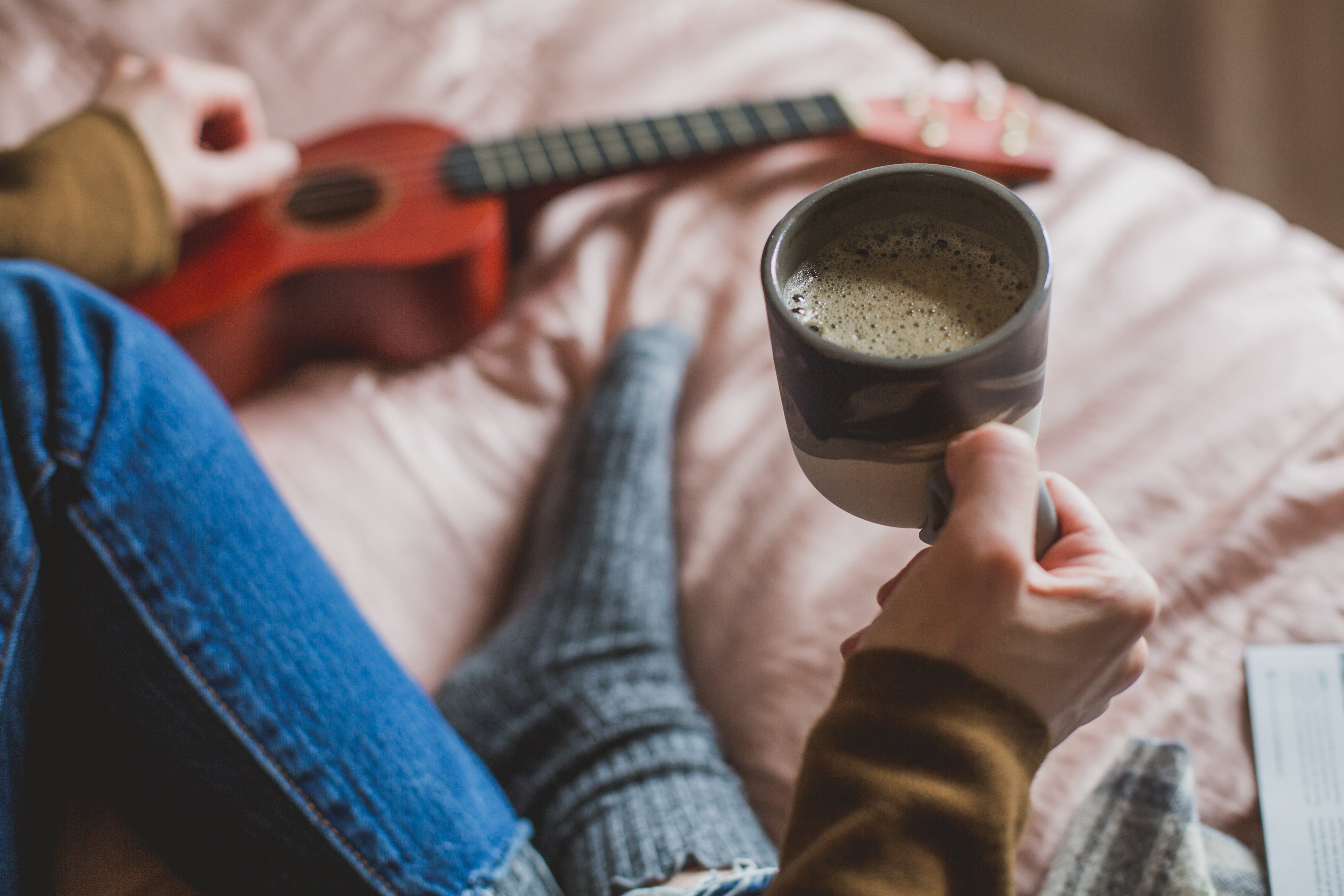 Holding mug of coffee in bed