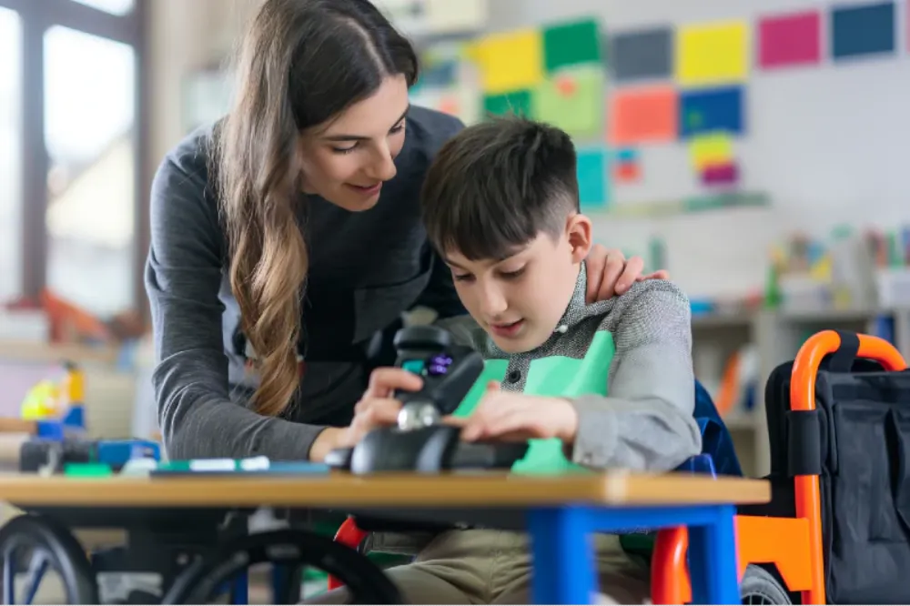 Teacher assisting a student with a robot in a classroom setting
