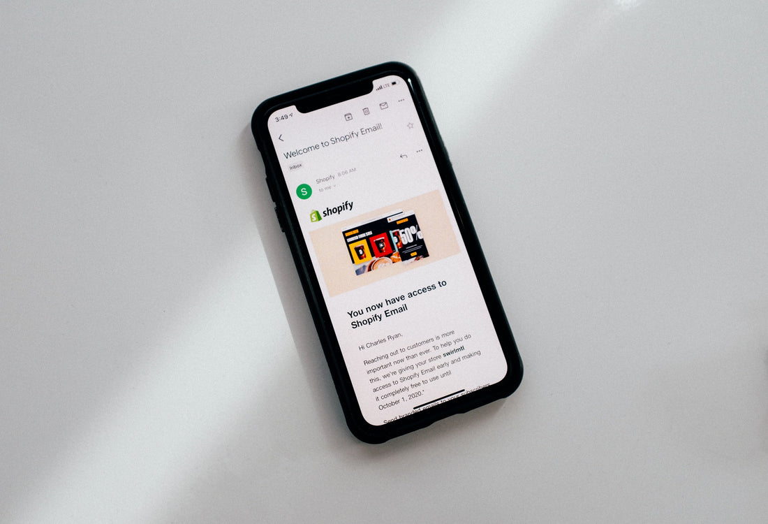 A flat lay of a mobile phone with a Shopify article displayed on the screen.