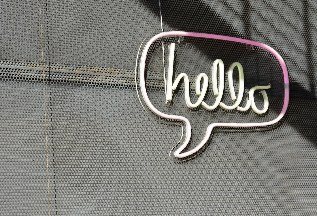 A "hello" signage encased in a chat bubble hanging on a screen wall.