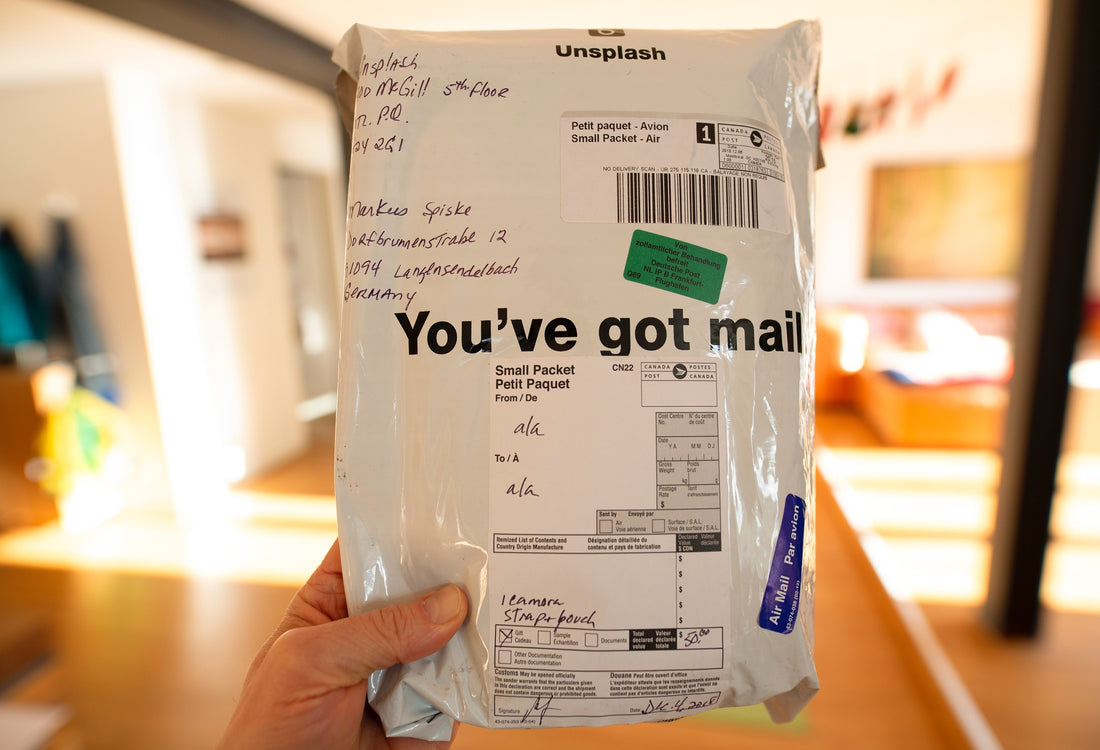 A hand holding up a small package.