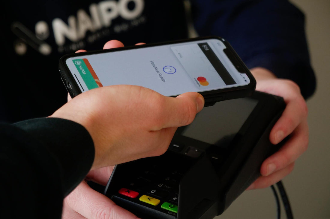 A hand holding a phone that is being used for online payment and checkout.
