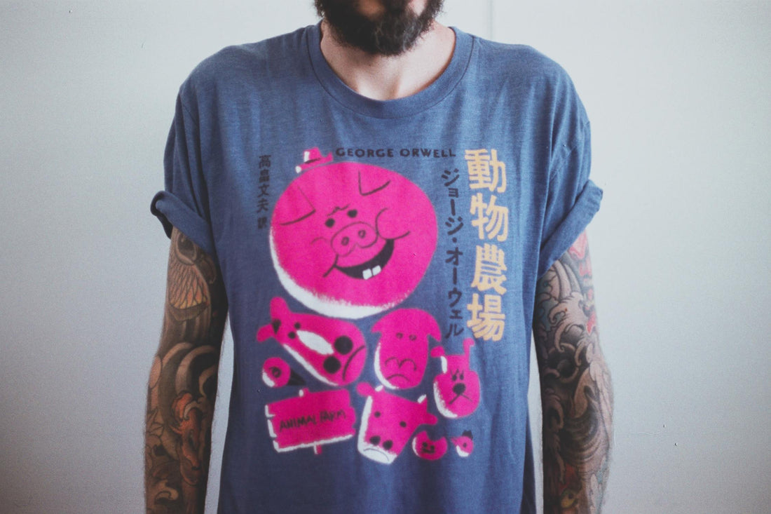 A tattooed man wearing a graphic t-shirt.