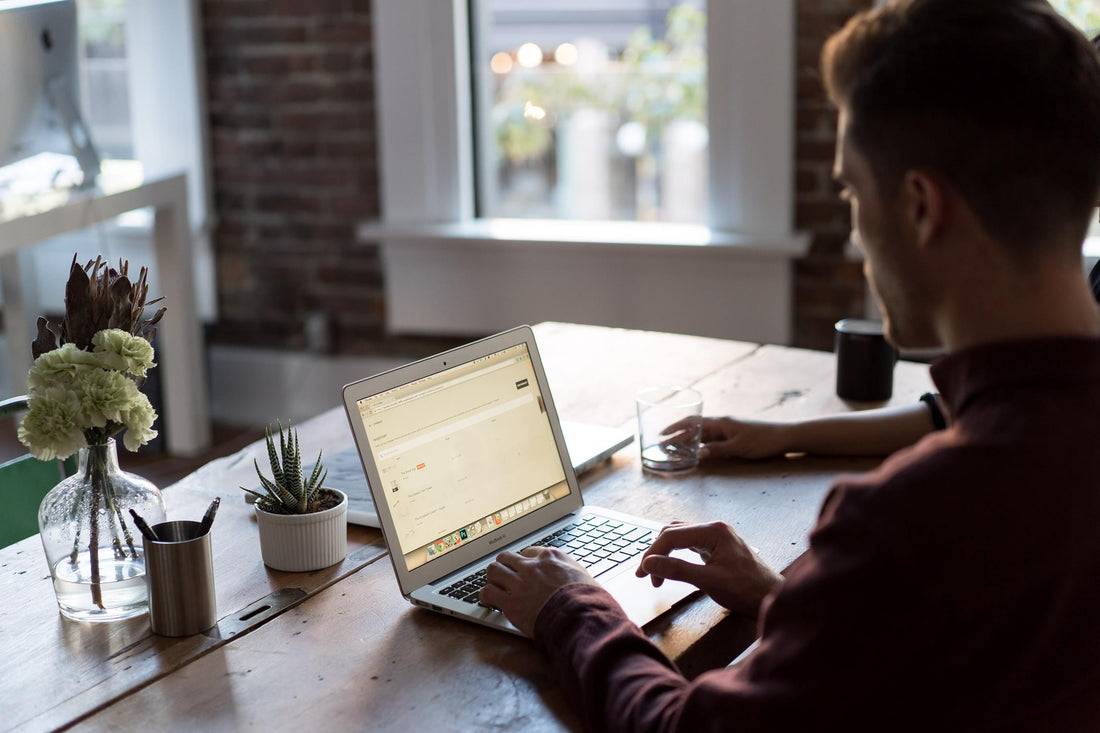 A man sitting at a desk working on his laptop.