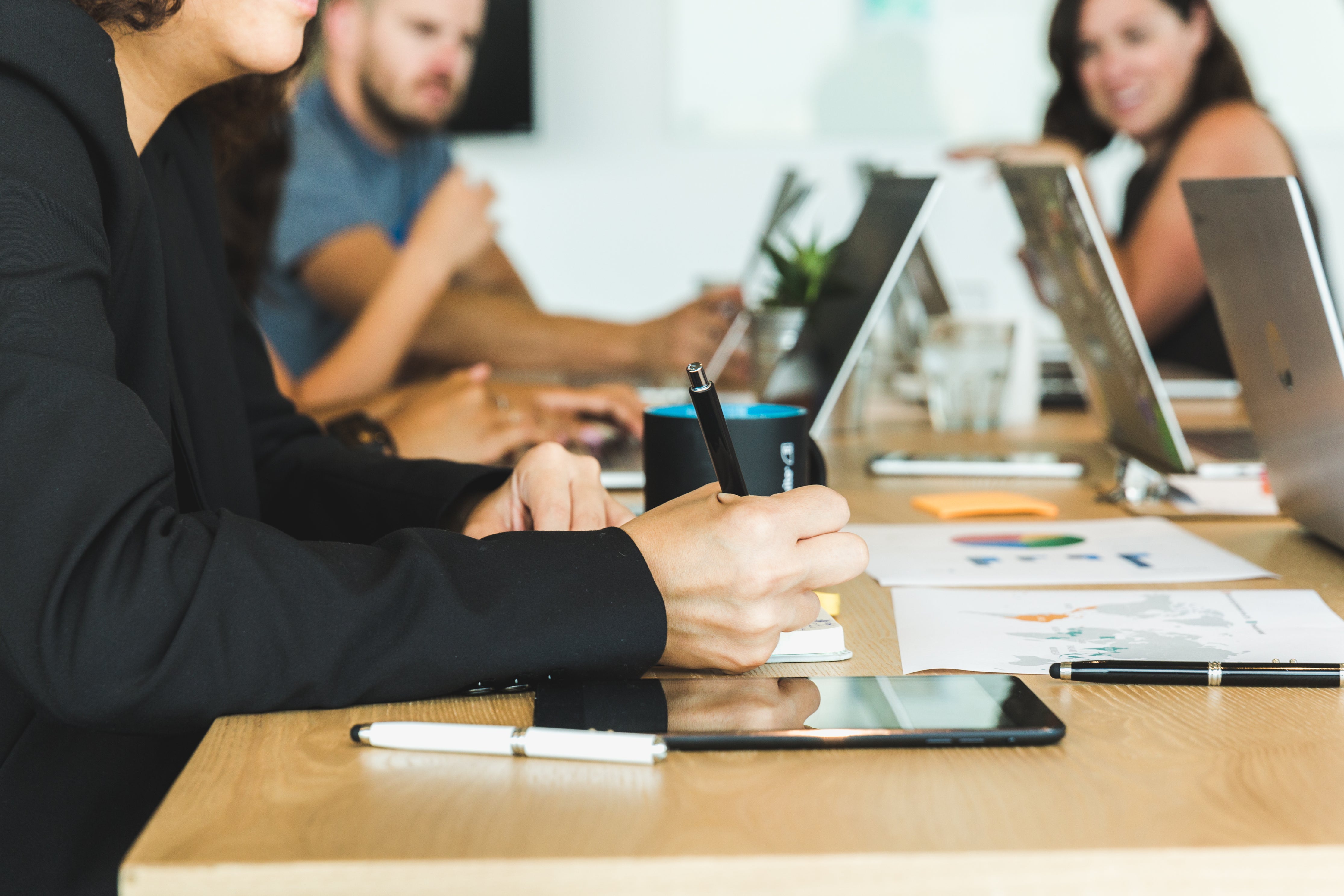 Woman Taking Notes During Team Meeting Photo